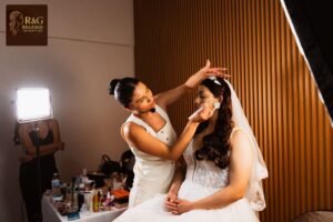 Professional makeup artist carefully applying eyeshadow to a bride during a wedding preparation session.